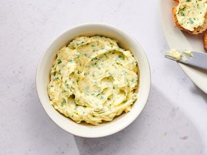 A bowl of garlic butter served with a platter of crusty bread