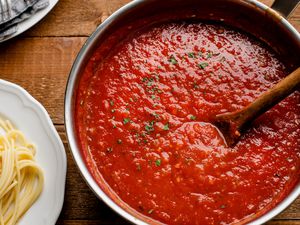Cooked classic tomato sauce in a pot with a wooden spoon