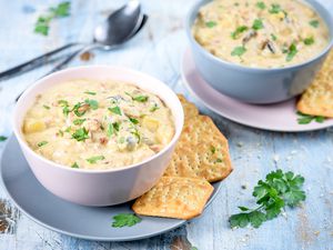 Slow cooker clam chowder in bowls with crackers