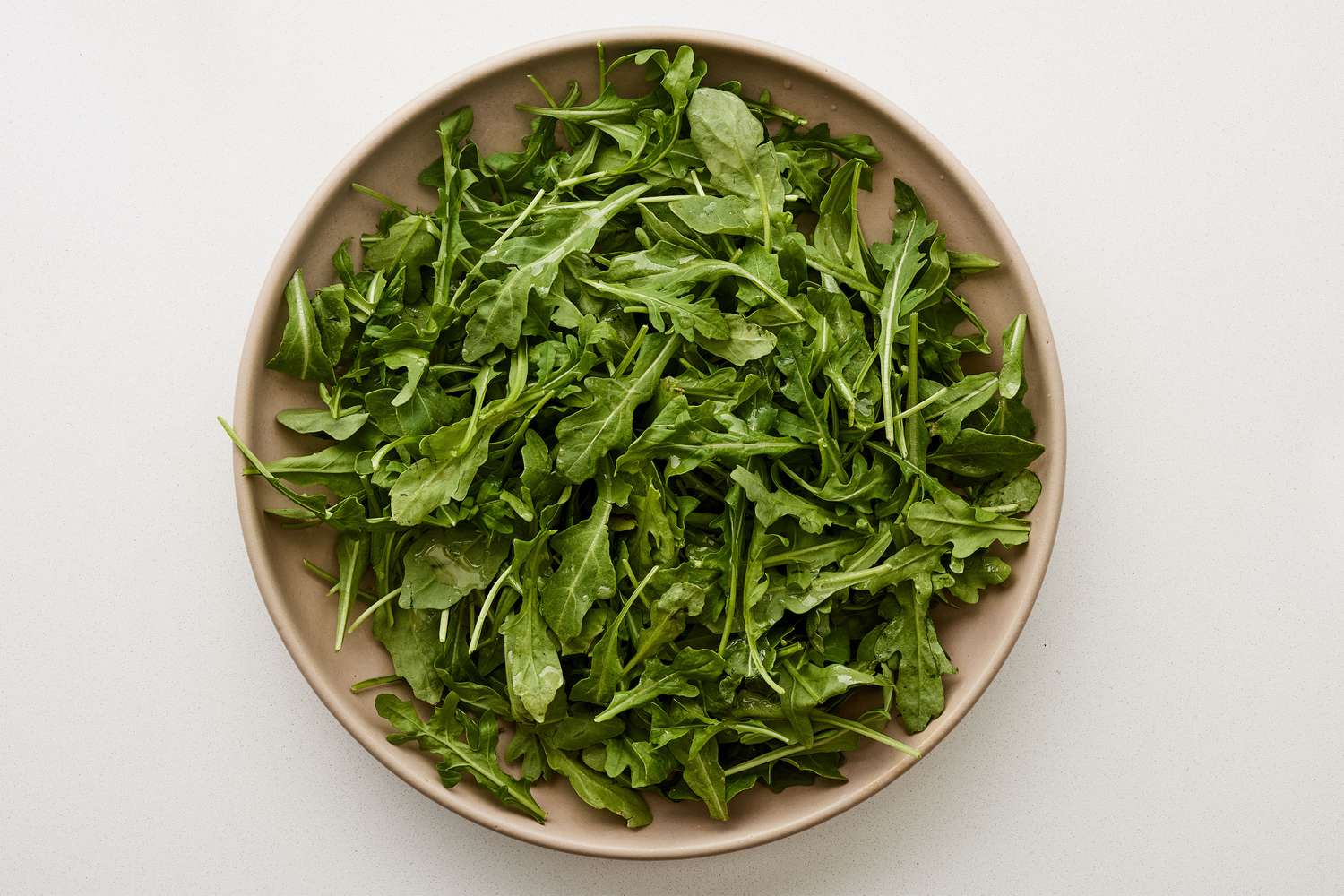 A large platter of arugula tossed in lemon dressing