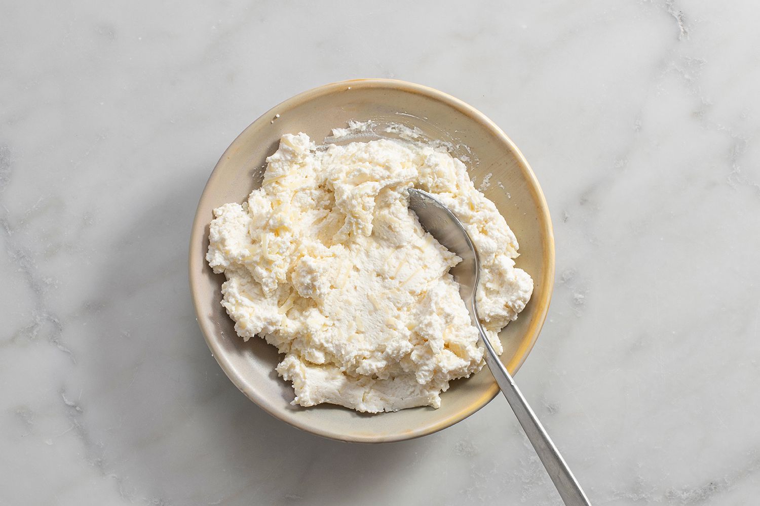 A small bowl with Parmigiano-Reggiano and mozzarella