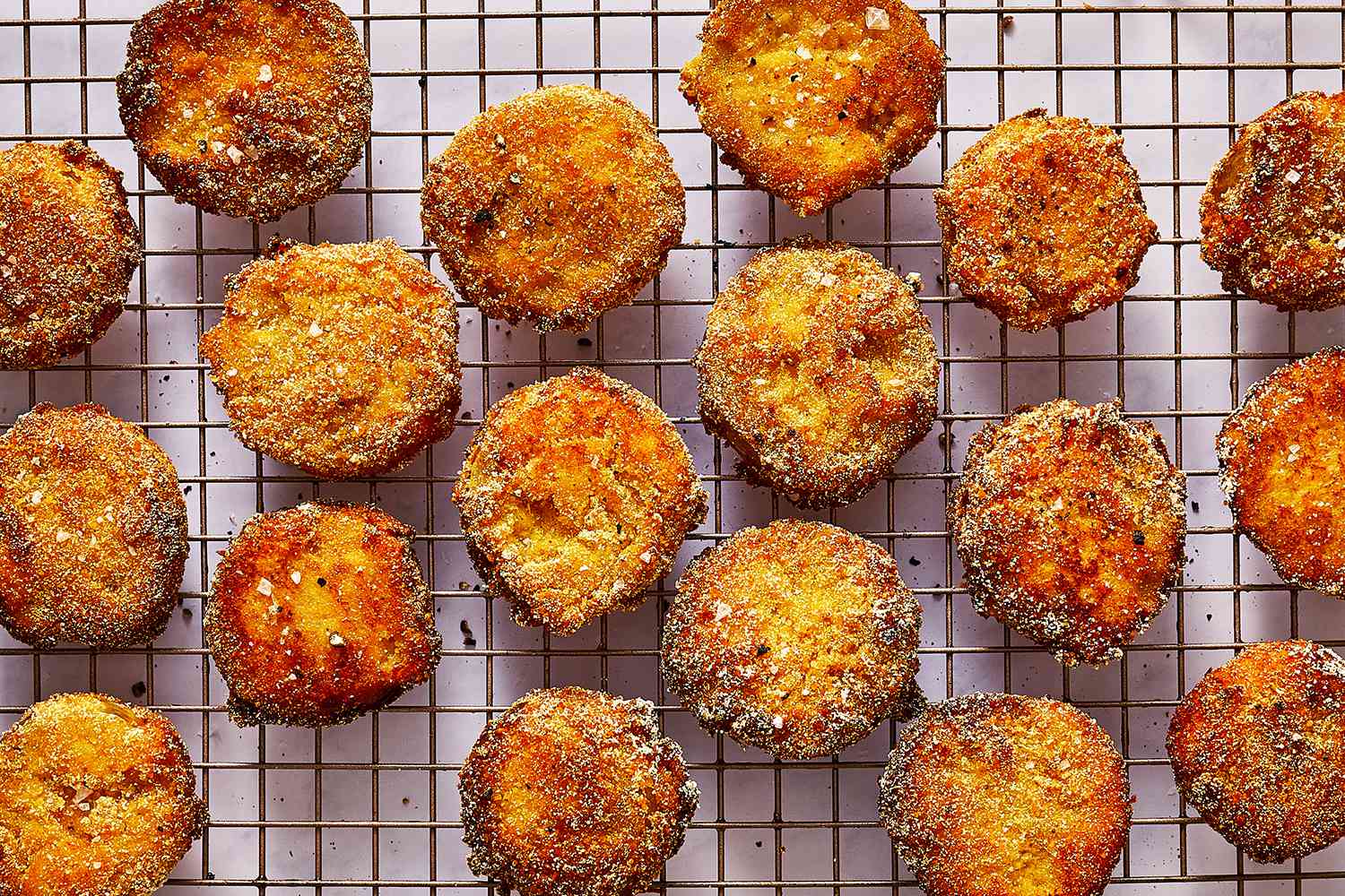 fried green tomatoes cooking on a wire rack