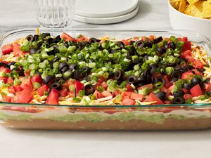 A large dish of 7-layer dip served with tortilla chips