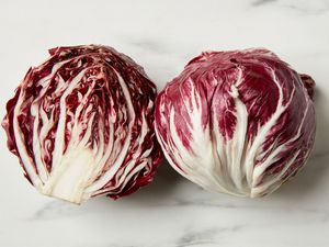 A head of radicchio, cut in half, on a marble surface