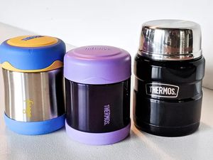 Several of the best hot food thermoses we recommend on a white countertop