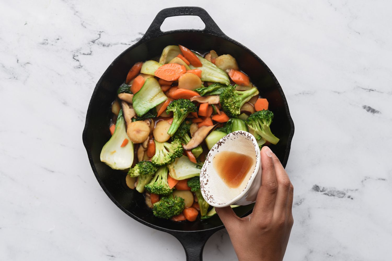 add sesame oil to the vegetables in the pan 