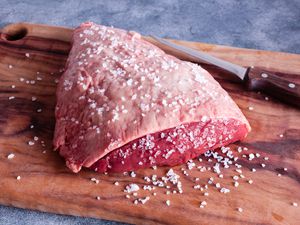 Picanha (Rump Cap) roast with salt on a cutting board