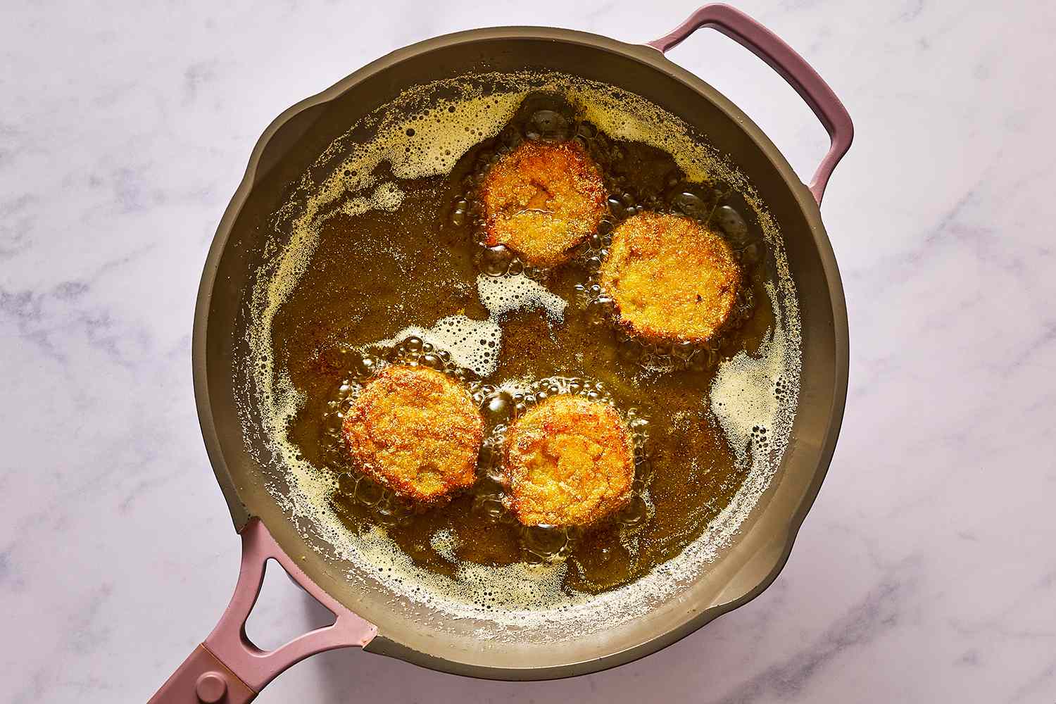 breaded green tomatoes frying in oil