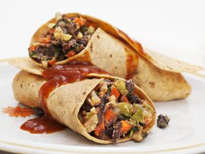 Close up of spicy black bean veggie burrito on plate