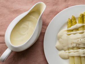 Basic white sauce (béchamel)in a gravy boat and drizzled over white asparagus
