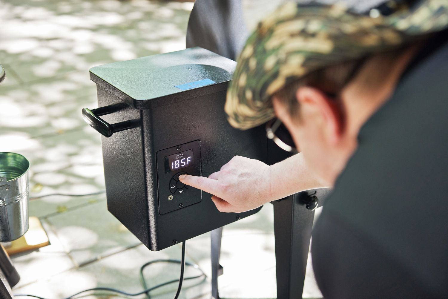 Person setting temperature on the Traeger Tailgater Pellet Grill