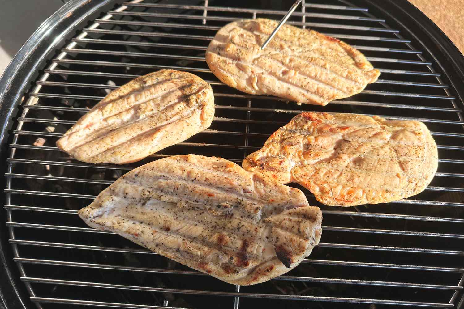 Chicken cooking on a grill over Royal Oak Hardwood Lump Charcoal