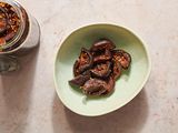 A bowl of soy sauce pickled shiitake mushrooms, next to a jar of pickled mushrooms