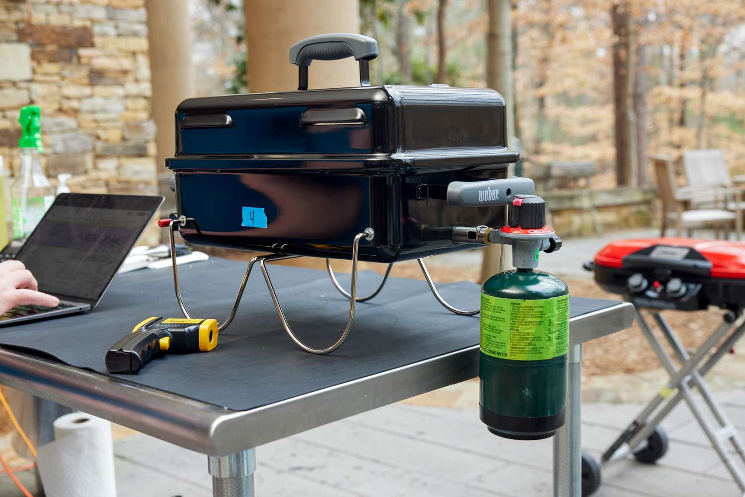 Weber Go-Anywhere Charcoal Grill and its gas on a table