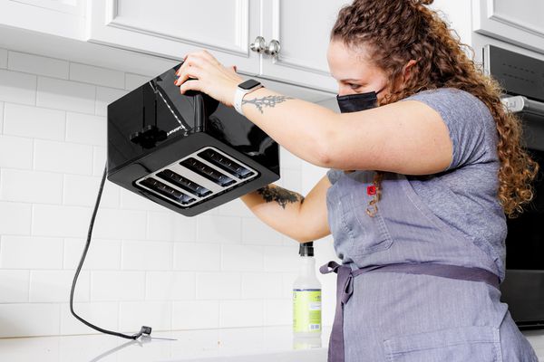 Person holding the Cuisinart CPT-T40 4-Slice Touchscreen Toaster upside down