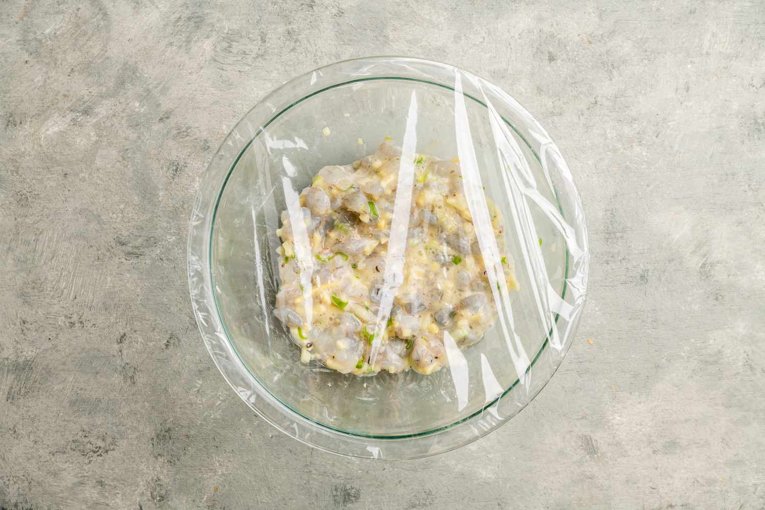 Har gow filling in a glass bowl covered with plastic