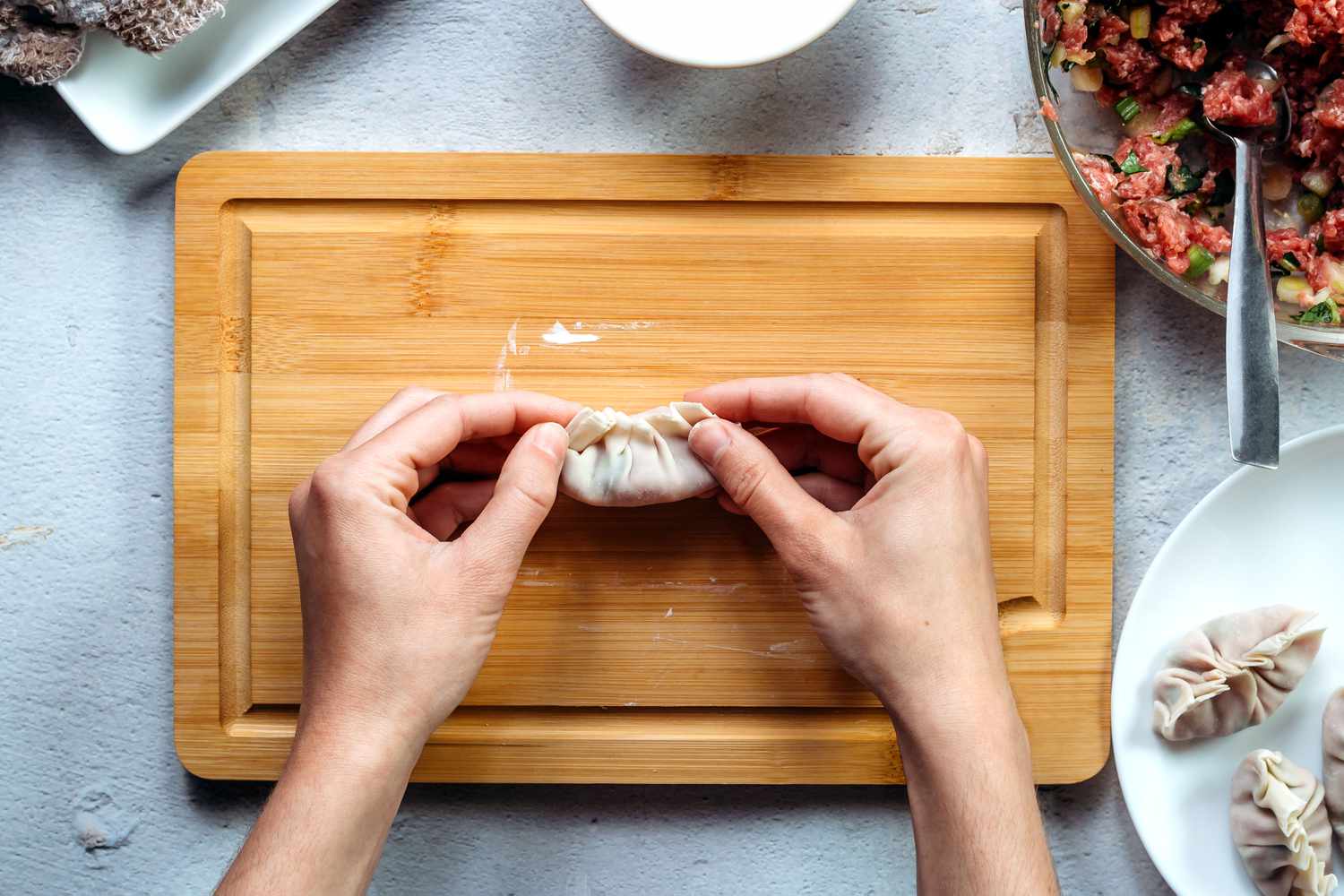 Dumpling is folded and sealed and edges are gathered and crimped