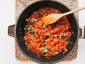 Homemade vegan tomato sauce in a skillet with a wooden spoon