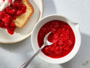 No-Cook Raspberry Sauce in a bowl, and over a slice of cake on a plate 