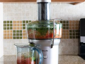 Breville Juice Fountain Compact Electric Juicer displayed on a kitchen counter with pulp