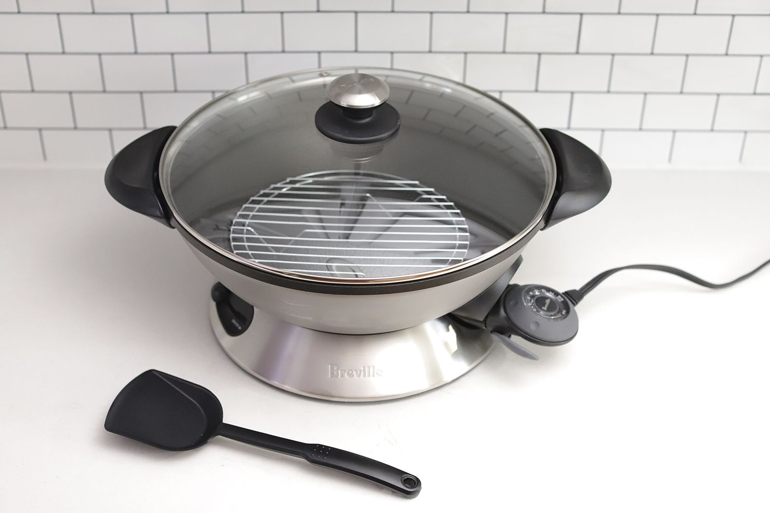 Breville Hot Wok Pro with accessories in a kitchen.