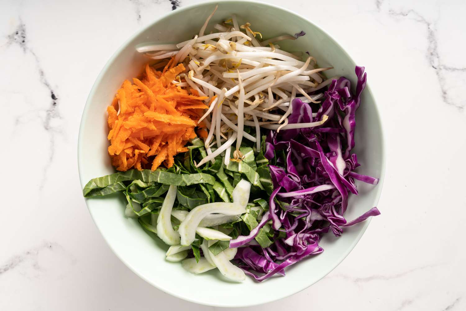 combine the shredded cabbage, carrots, bok choy and mung bean sprouts in a bowl