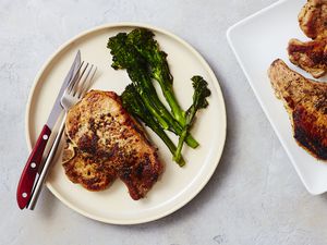 Oven-roasted pork chops on a plate with broccolini