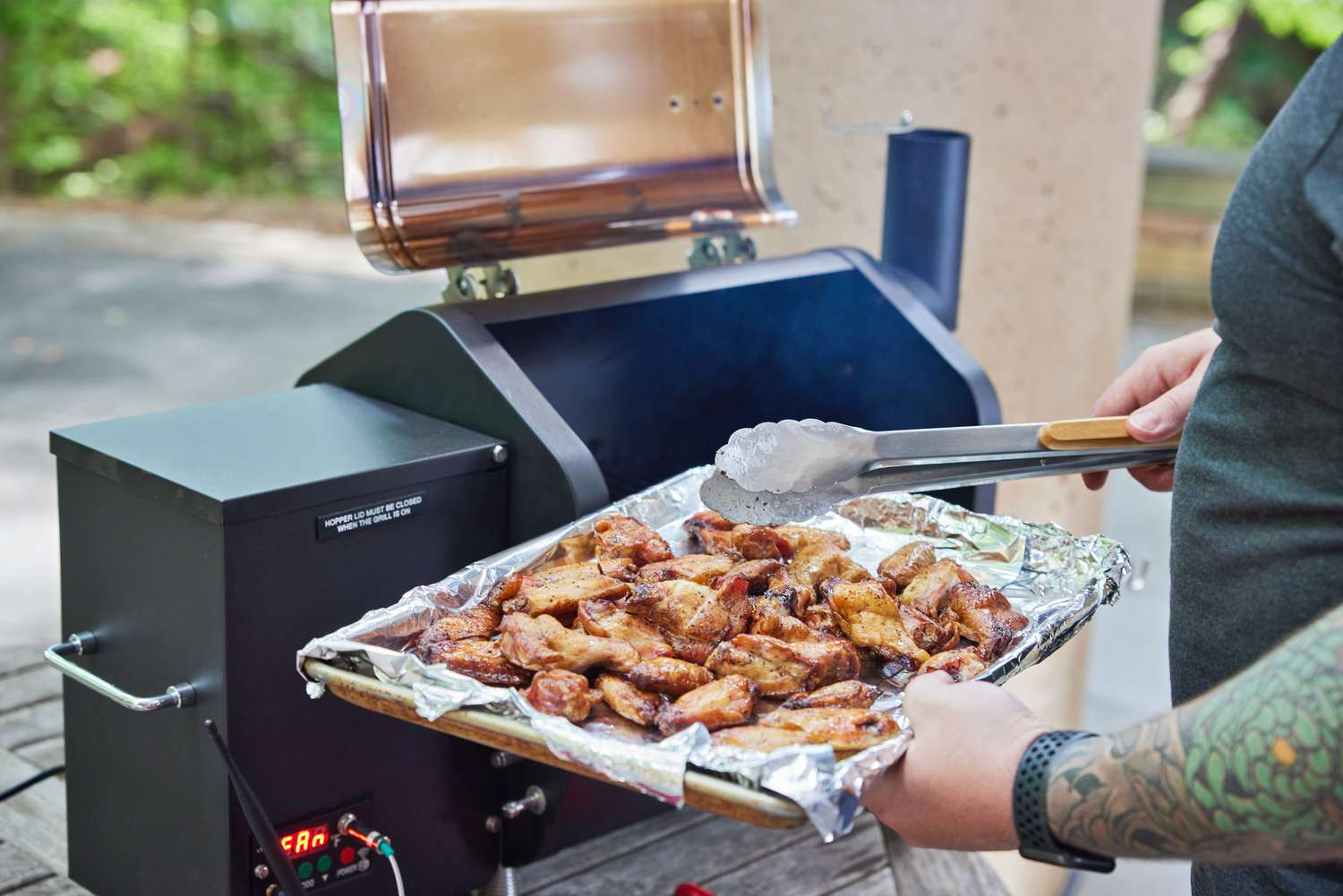 Placing chicken wings on a Green Mountain pellet grill