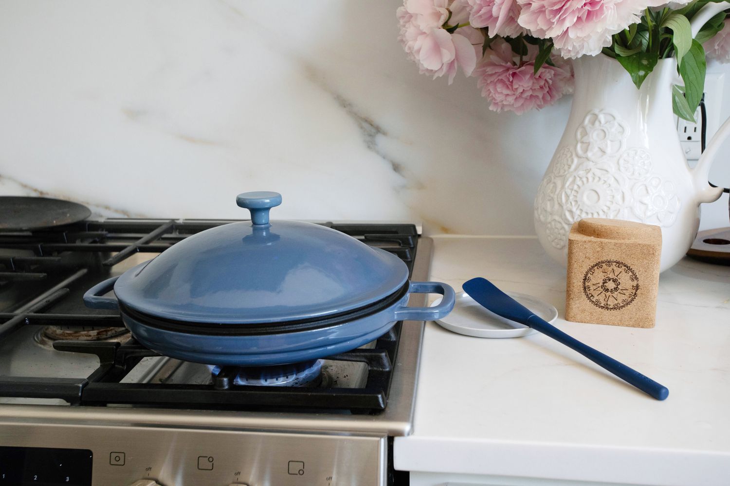 Blue Our Place Cast Iron Hot Grill sitting on stovetop with lid on