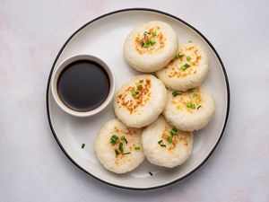 Japanese pan-fried rice cakes on a plate with dipping sauce