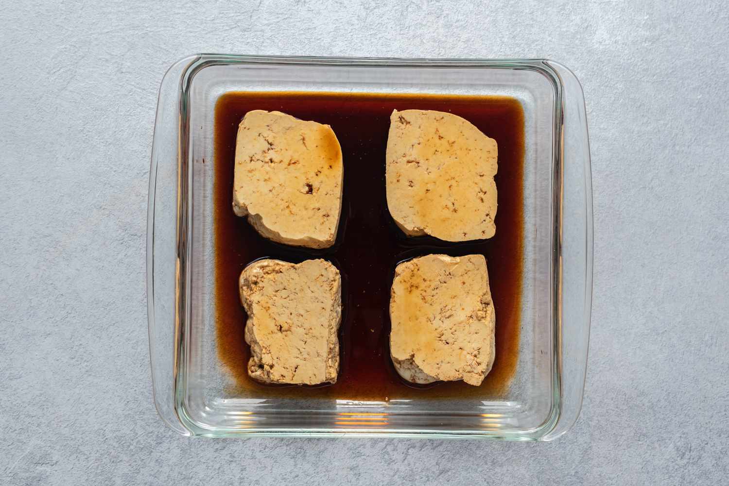 Tofu in a shallow dish with soy sauce 