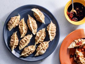 Thai Steamed Dumplings on plates With Dipping Sauce in a bowl 