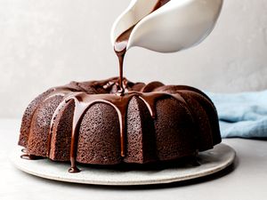 Pouring chocolate glaze over a chocolate Bundt cake