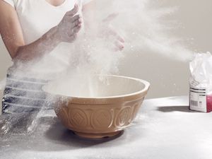 Woman's hands covered in flour while baking