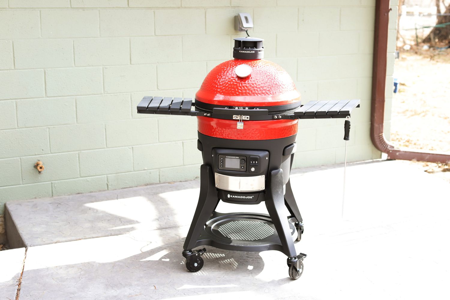 A Kamado Konnected Joe grill in a yard