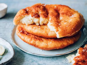 Hungarian fried lángos stacked on a plate