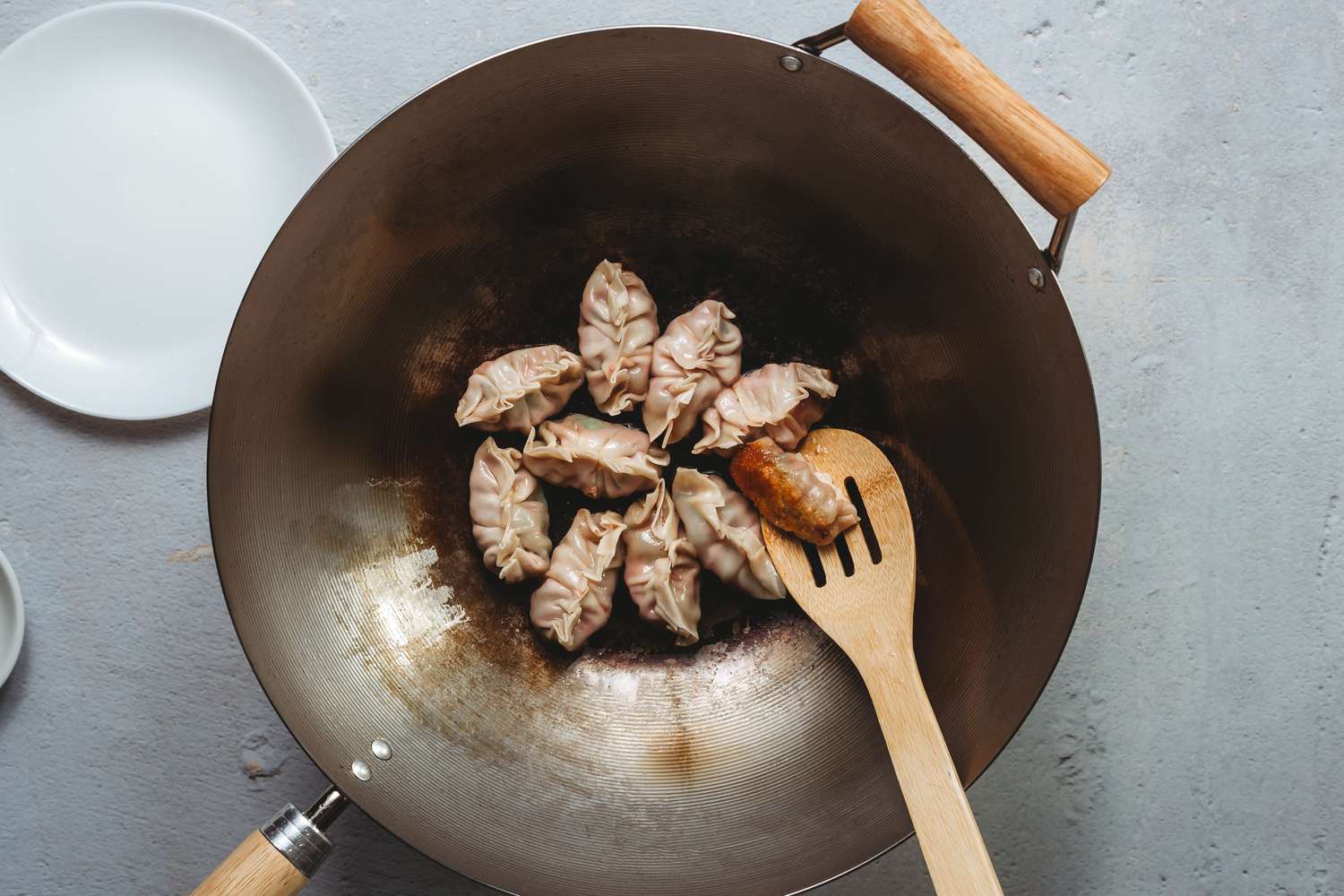 Chinese dumplings cooking in a wok until the bottoms are browned