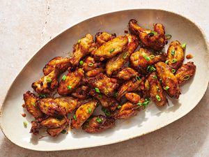 A large platter of air fryer honey garlic wings, garnished with sliced scallions