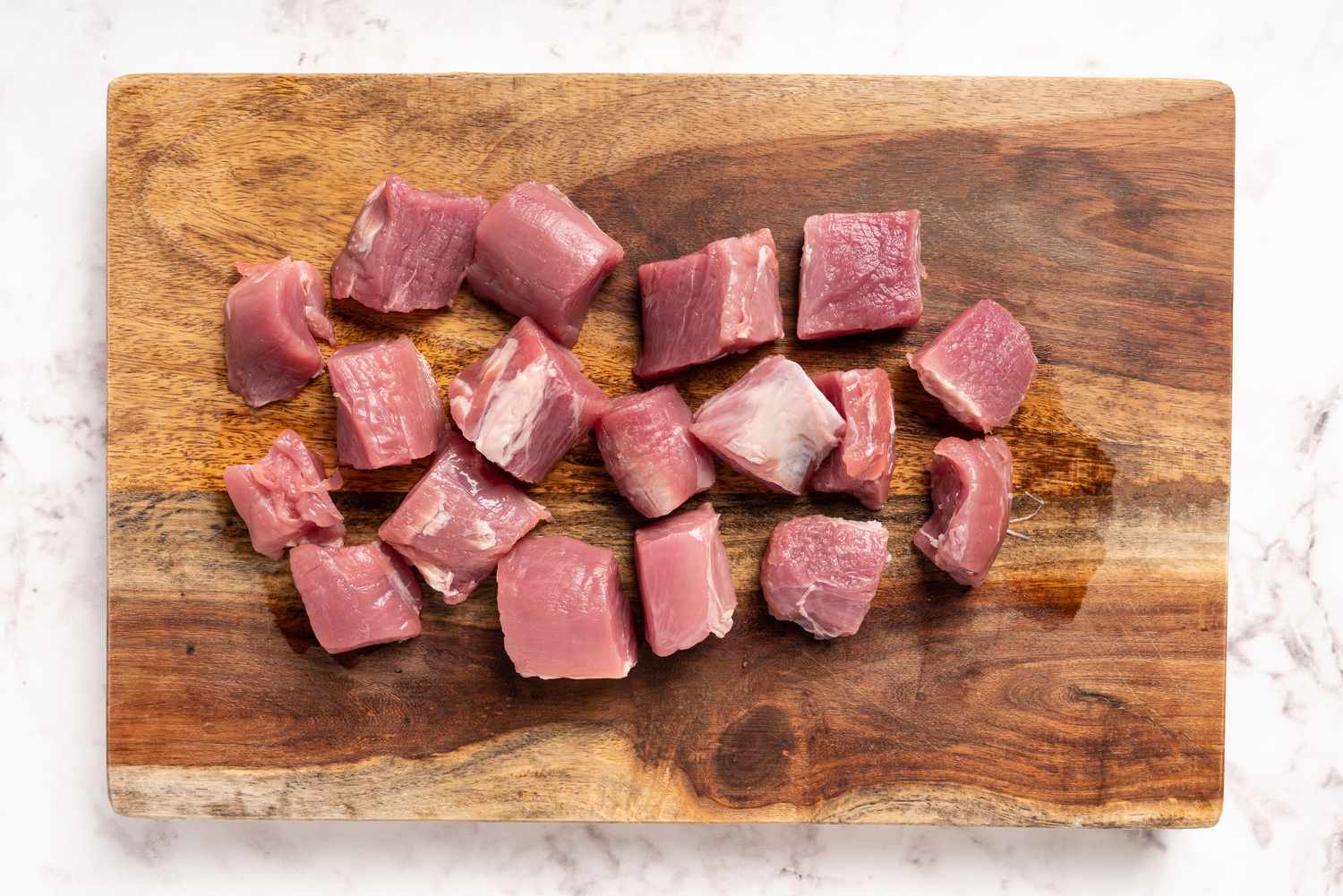 Pork cubes on a wooden cutting board