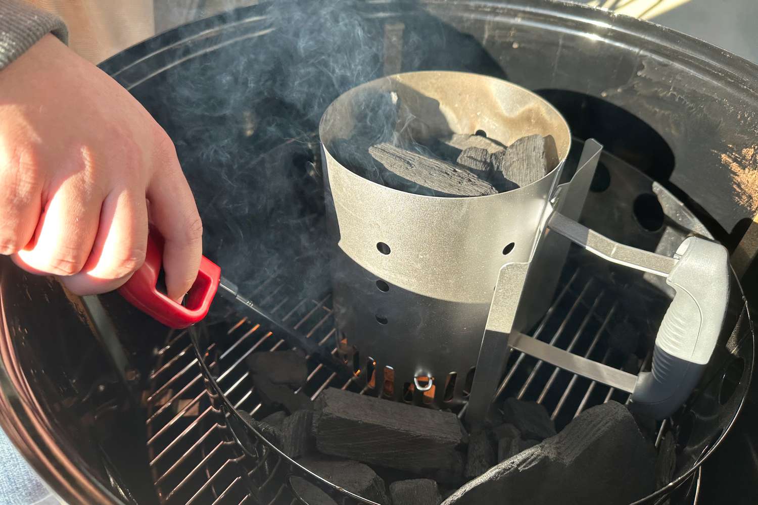 Hand lighting Royal Oak Hardwood Lump Charcoal in a grill