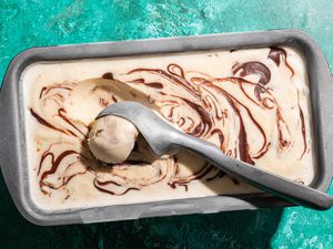 Peanut Butter Whiskey Ice Cream in a container with an ice cream scoop