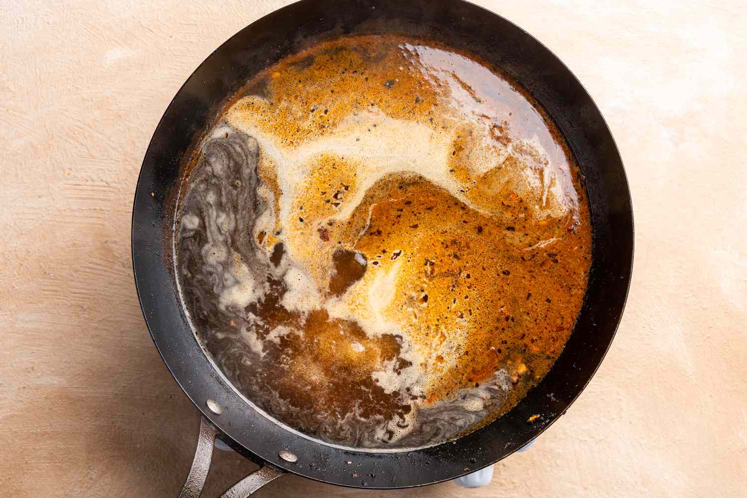 beef stock added to the mixture in the pan 