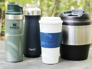 Best travel mugs displayed outdoors on table