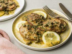 Classic veal piccata on a white rimmed plate