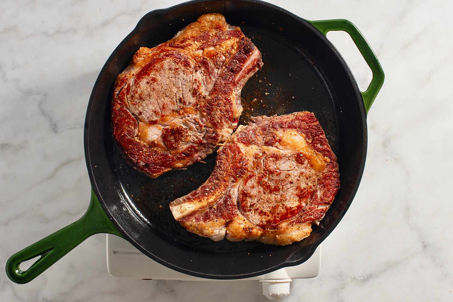 steaks searing in cast iron skillet