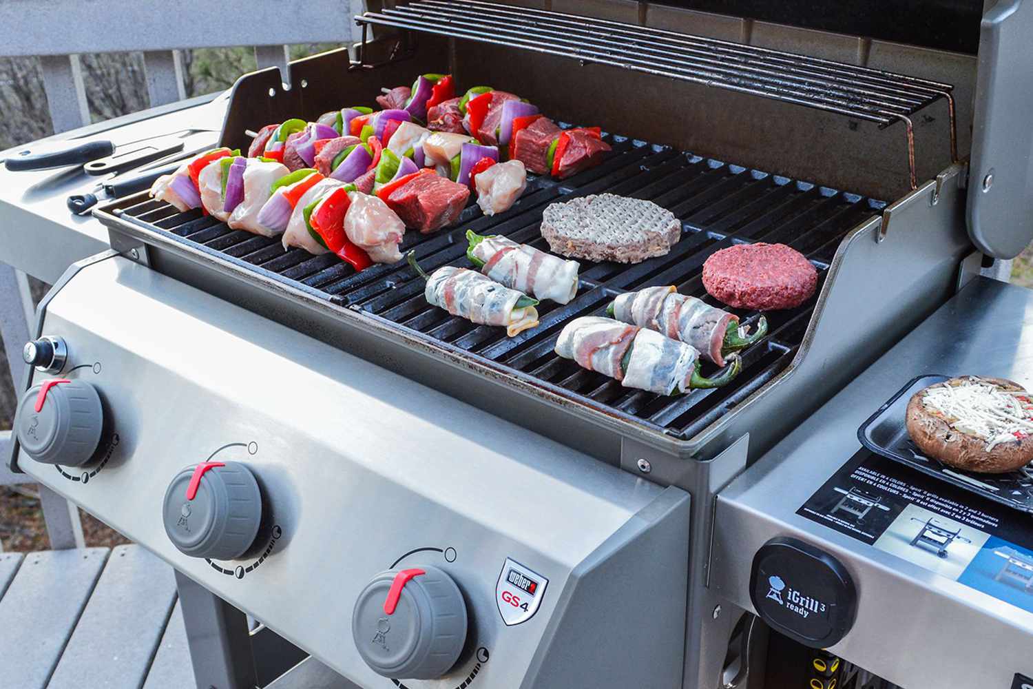 Weber Spirit E-310 Gas Grill with shish kebabs and hamburgers grilling