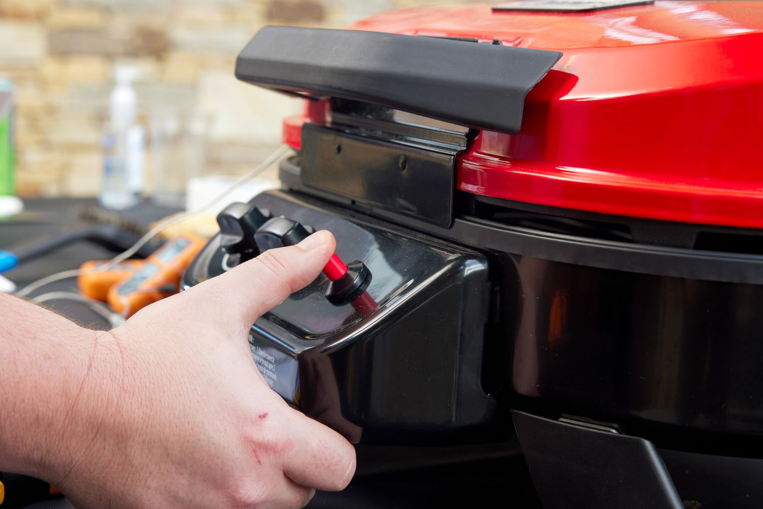 A man turns on the Coleman Roadtrip portable grill