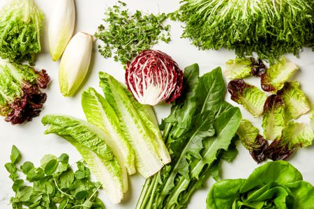 A variety of different types of lettuce on a marble surface