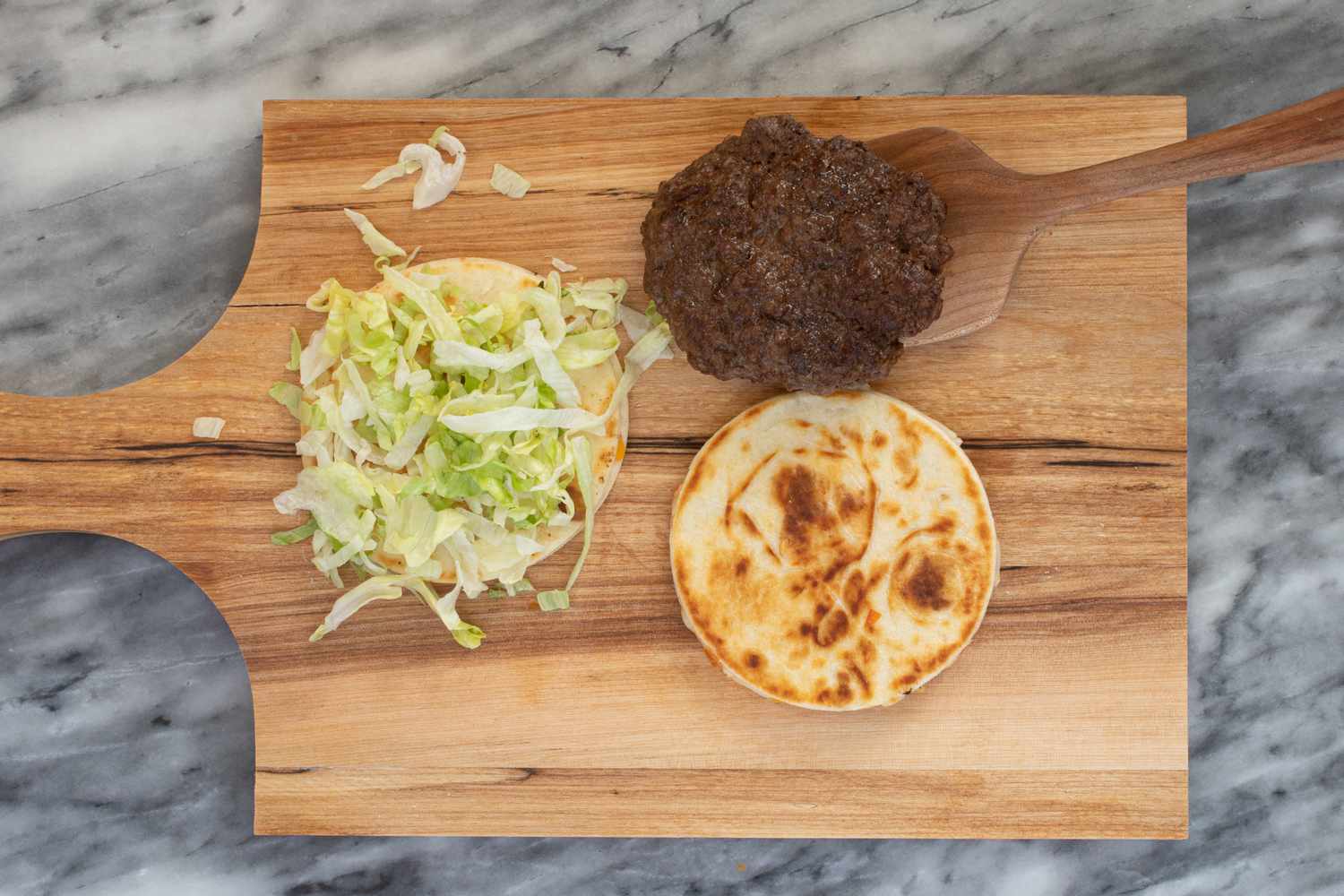 Assembling a quesadilla burger.