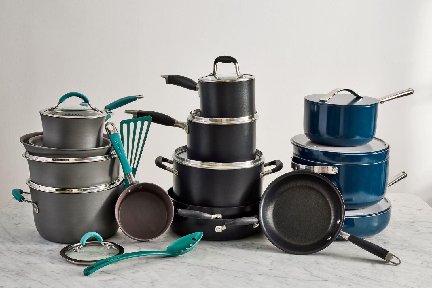 Several nonstick cookware sets displayed on a marbled surface